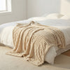 CloudHug Bubble Plush Blanket layered on a bed